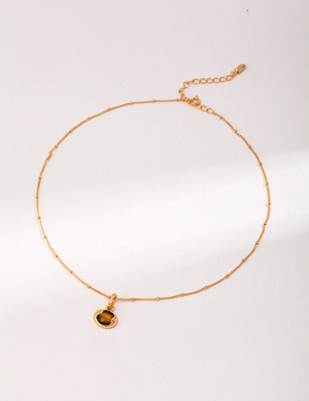 10mm genuine Tiger Eye stone with mesmerizing chatoyant effect resembling moving feline eye in vintage setting.