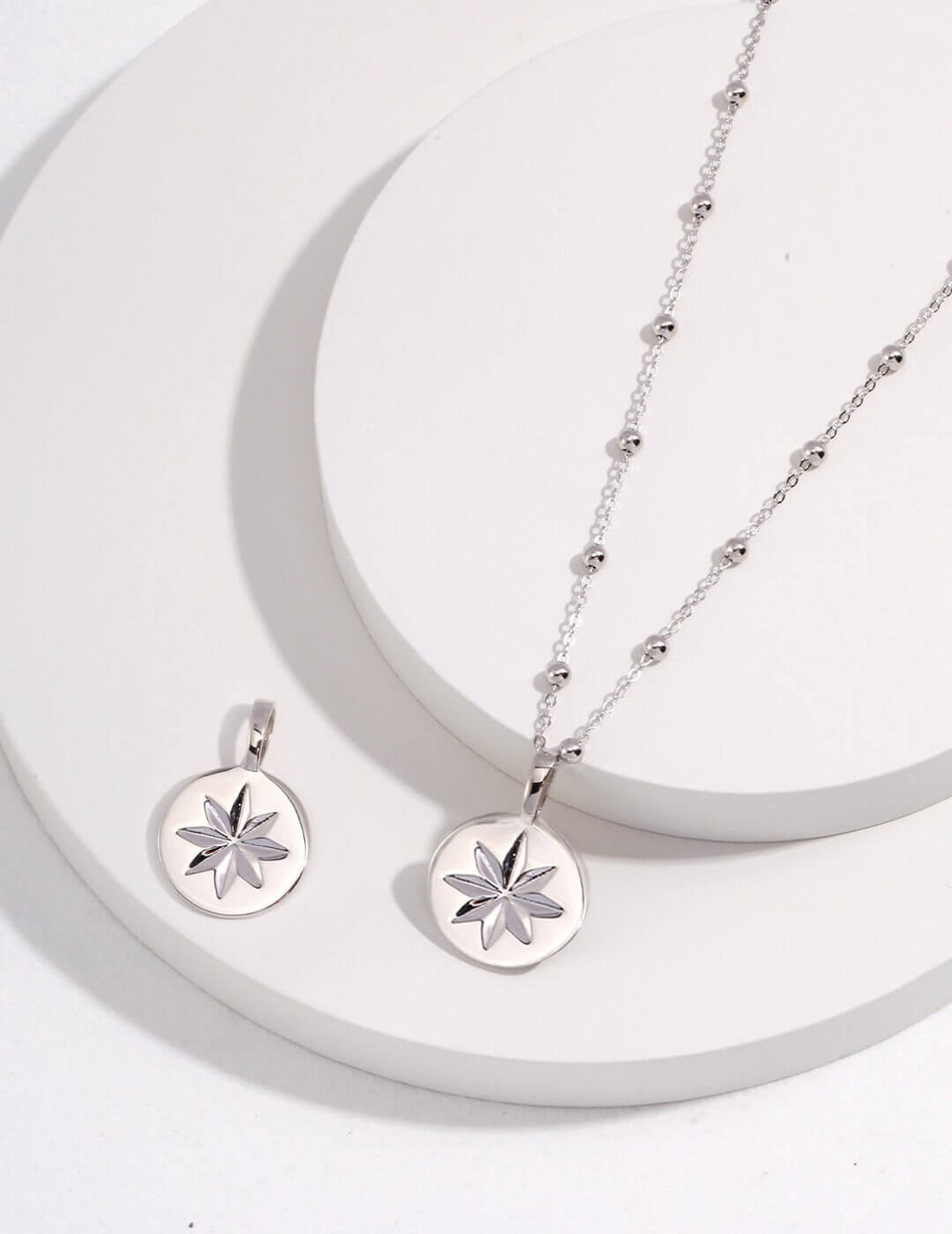 Silver necklace with star pendant on a white background