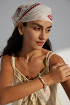 Hands demonstrating how to adjust the sliding knot on the bracelet.