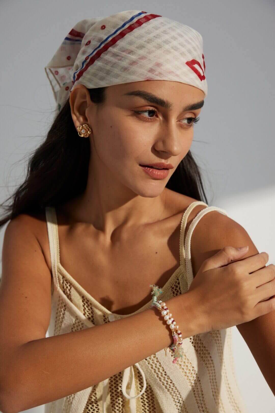 Hands demonstrating how to adjust the sliding knot on the bracelet.