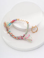 The bracelet artistically draped over a natural wood surface.