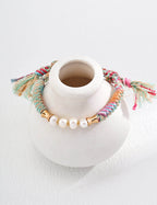 Front view of the adjustable natural pearl and twine wrap bracelet.