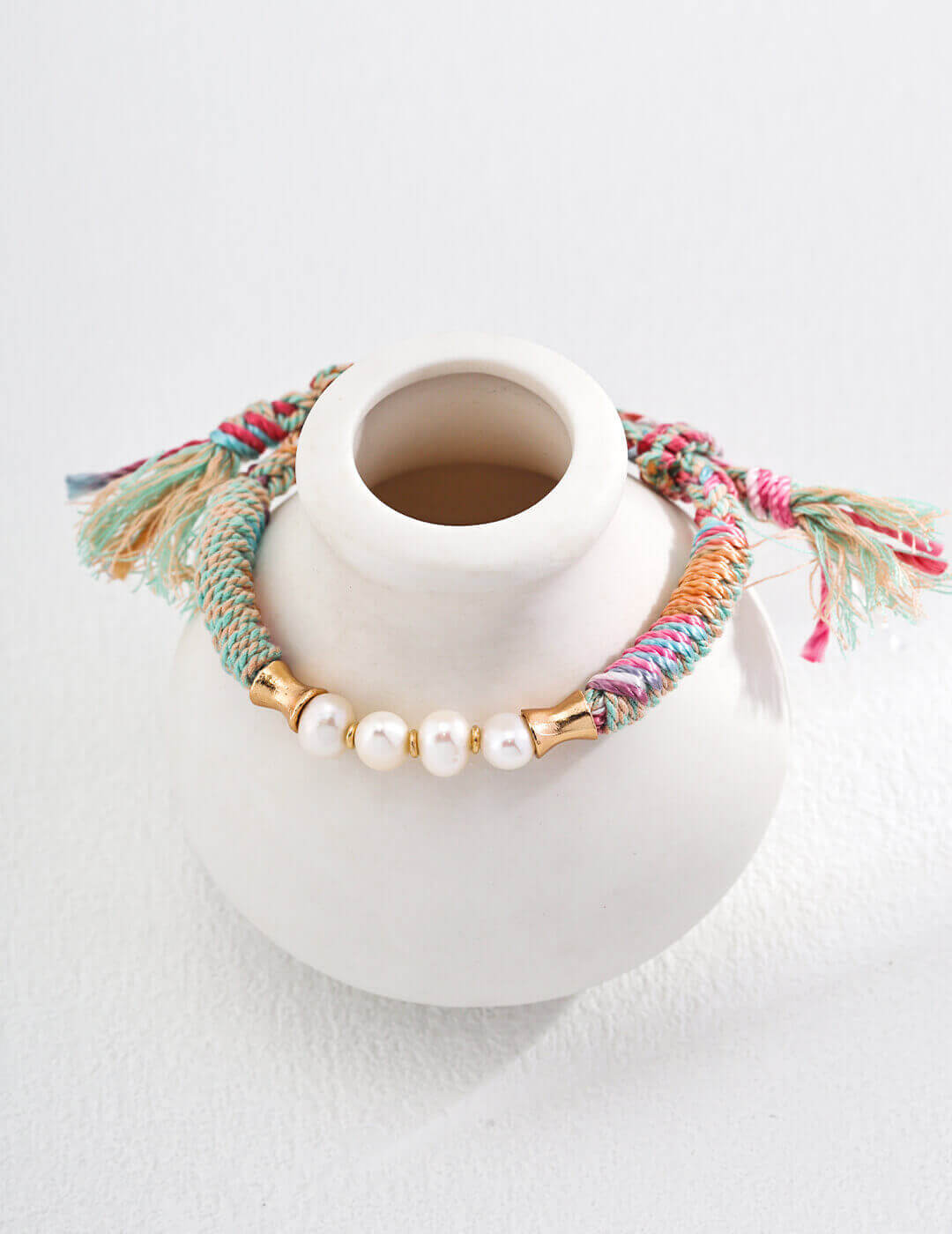 Front view of the adjustable natural pearl and twine wrap bracelet.