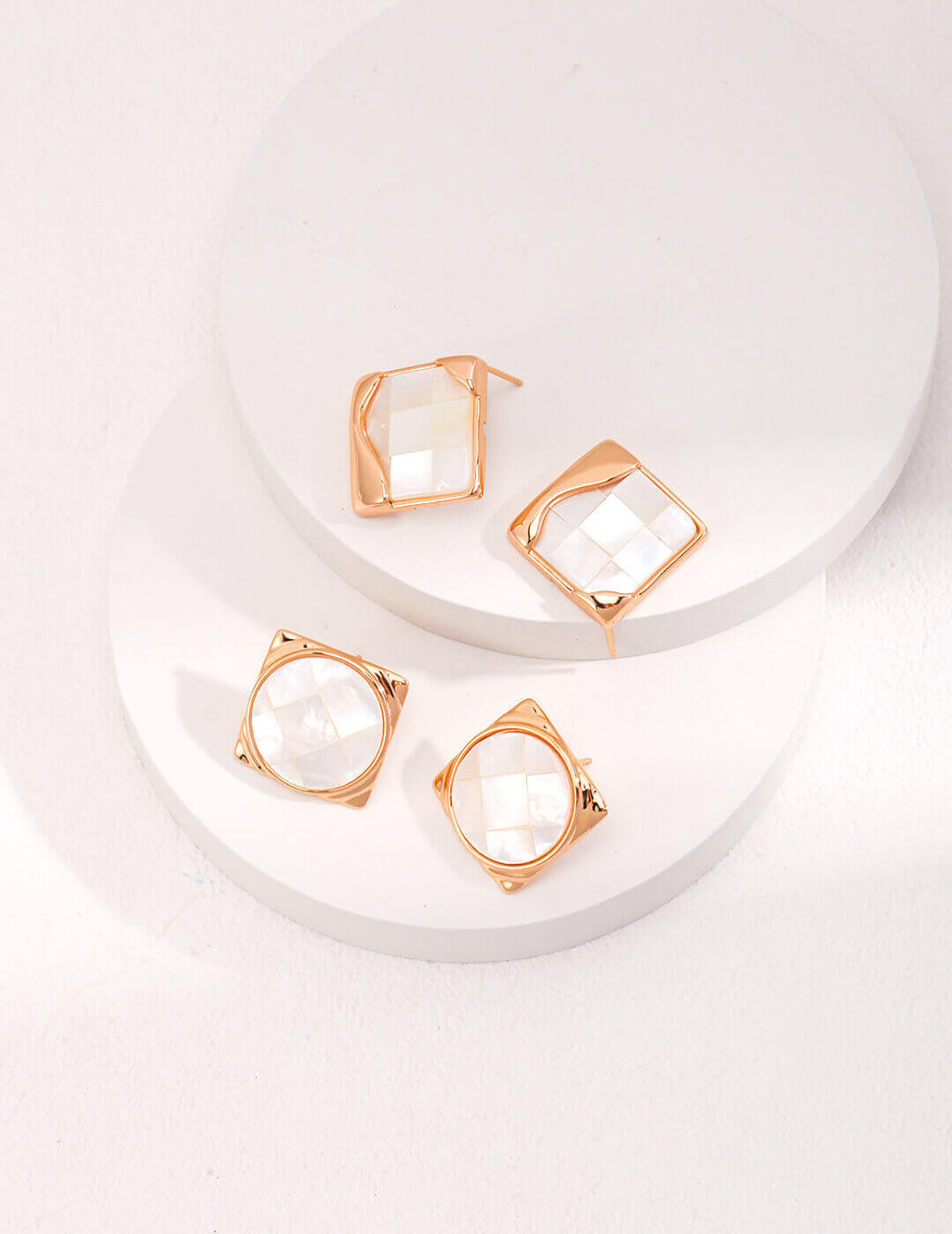 Model wearing mosaic shell earrings in artistic setting, highlighting historical and modern fusion.