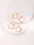 Model wearing mosaic shell earrings in artistic setting, highlighting historical and modern fusion.