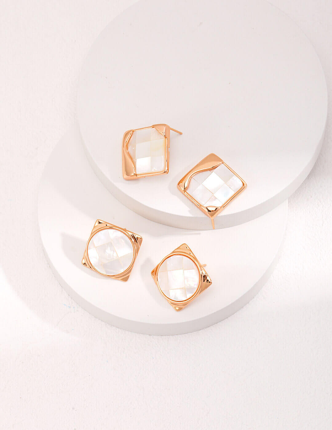 Model wearing mosaic shell earrings in artistic setting, highlighting historical and modern fusion.