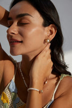 Close-up side view of a woman wearing the pearl stud earrings.