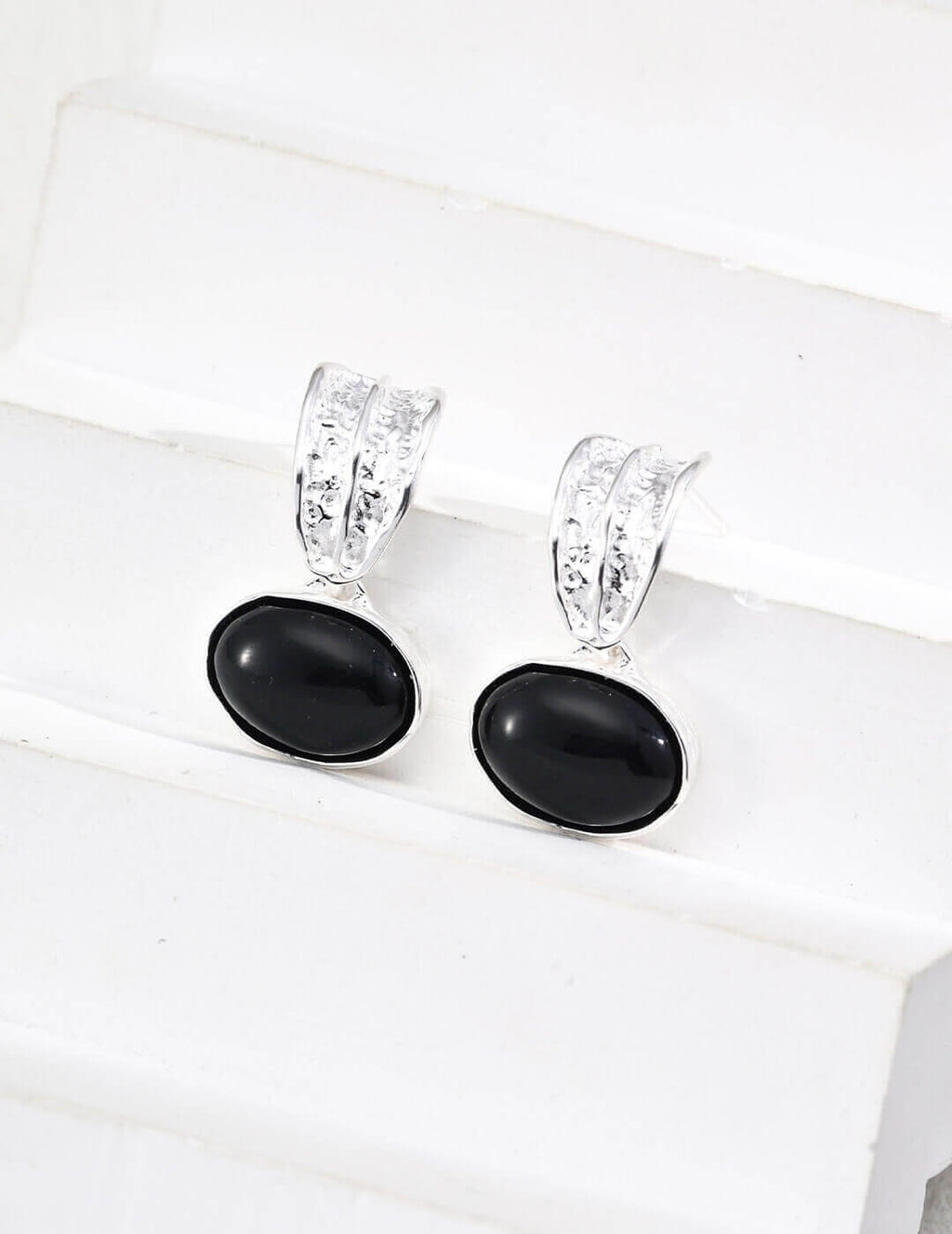 Side view of Black Onyx earrings on model, showcasing sophisticated black gemstones against skin tone.
