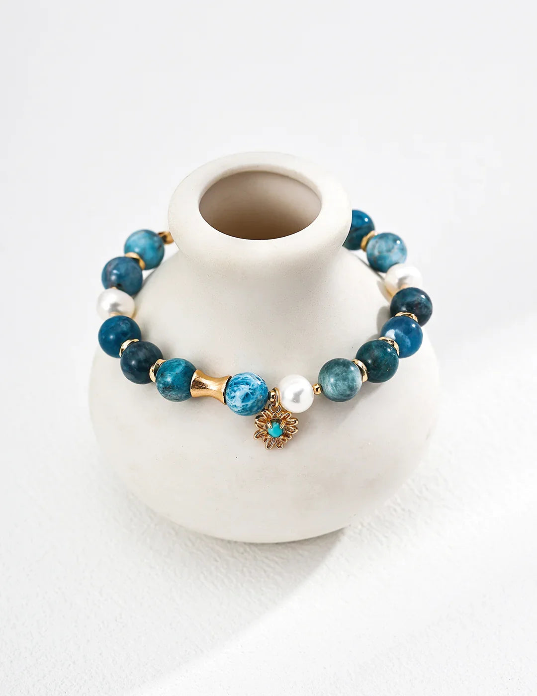 Front view of the Blue Harmony necklace, featuring a natural white pearl centered with raw azurite and turquoise gemstones on a silver chain.