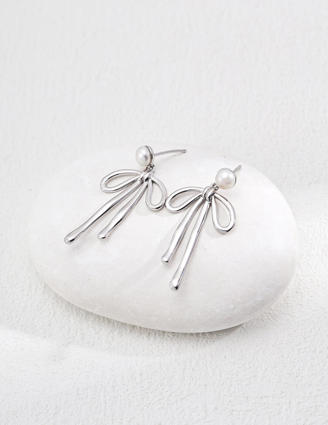 Silver earrings with pearls on a white stone