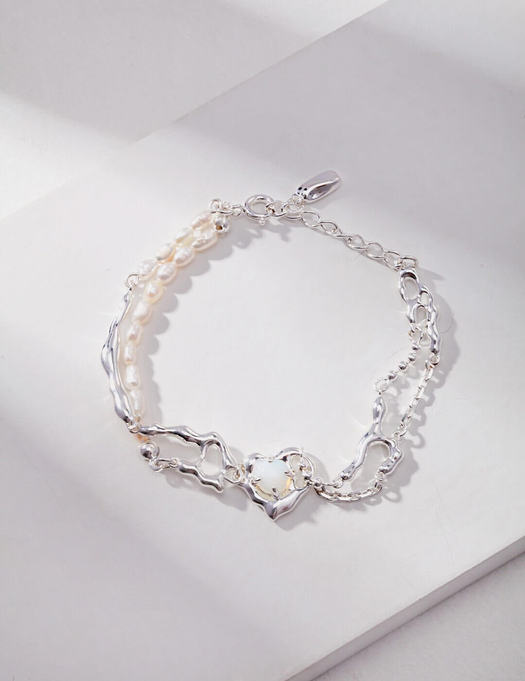 Silver bracelet with pearls on a light gray background