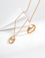 Gold necklace and ring on a white background