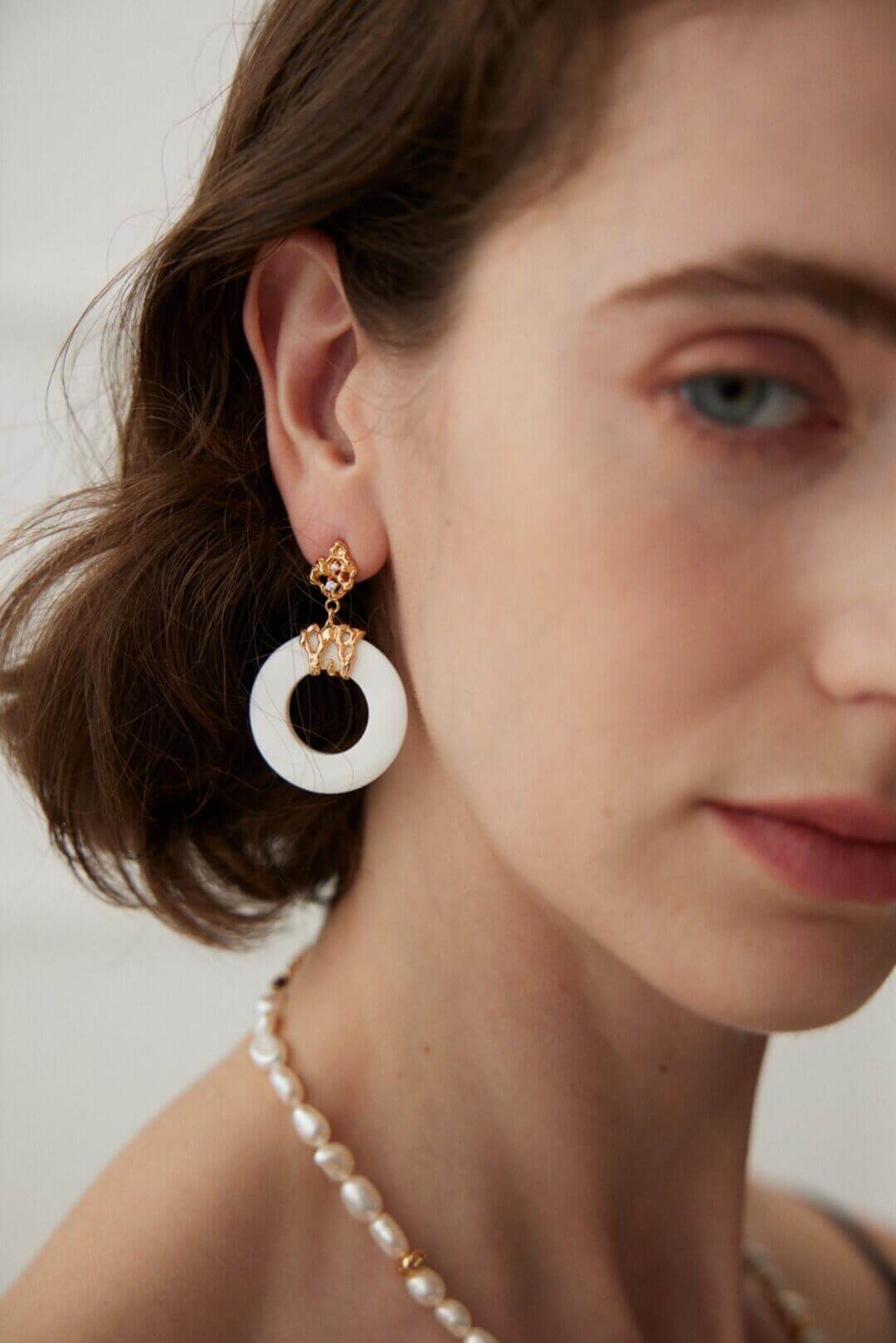 Close-up detail of the delicate hollow-out craftsmanship on the vintage white shell earrings.