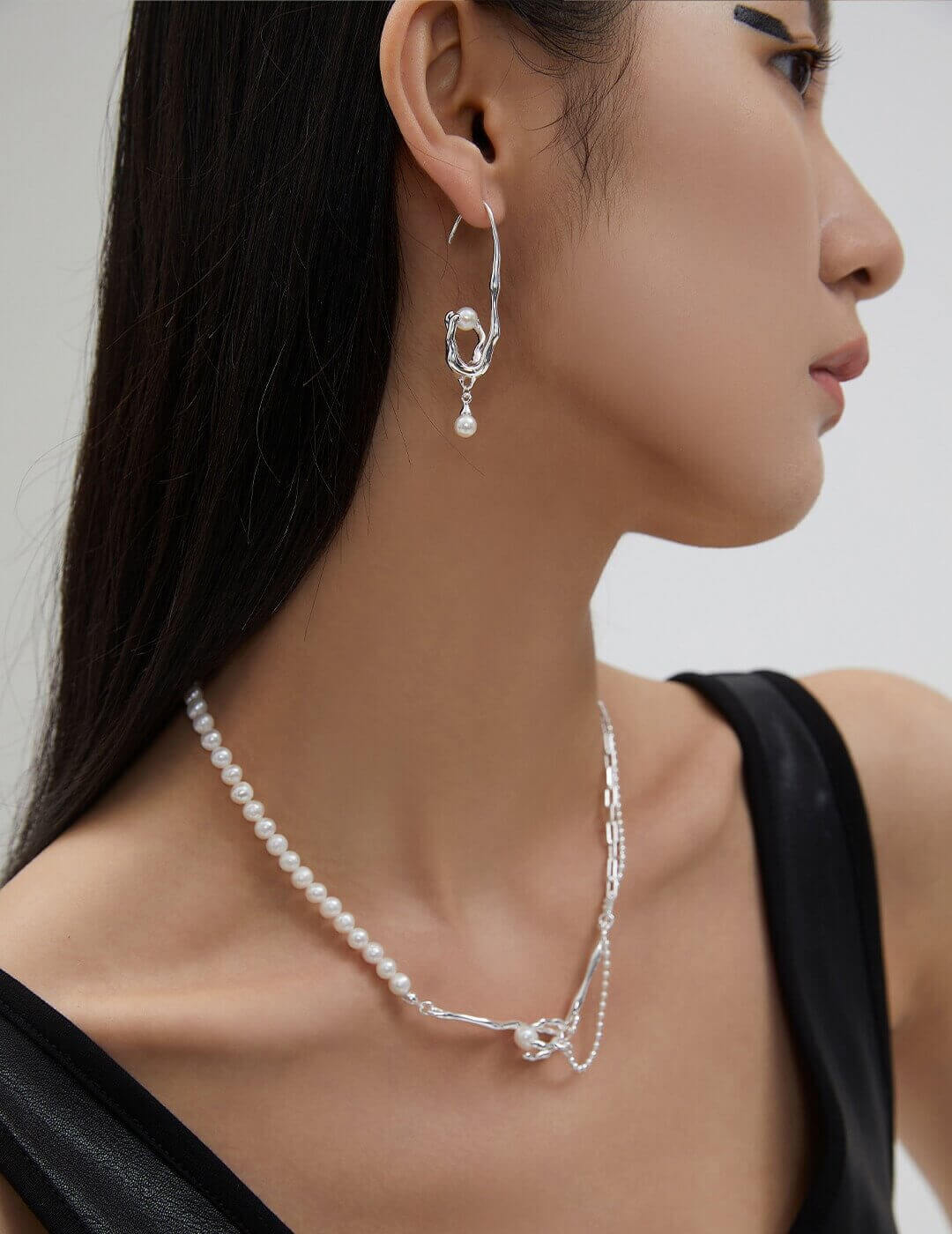 Close-up of the 'withered vine cradling a nest' design: silver claw setting symbolizes life's dusk, nurturing a pearl as new life.