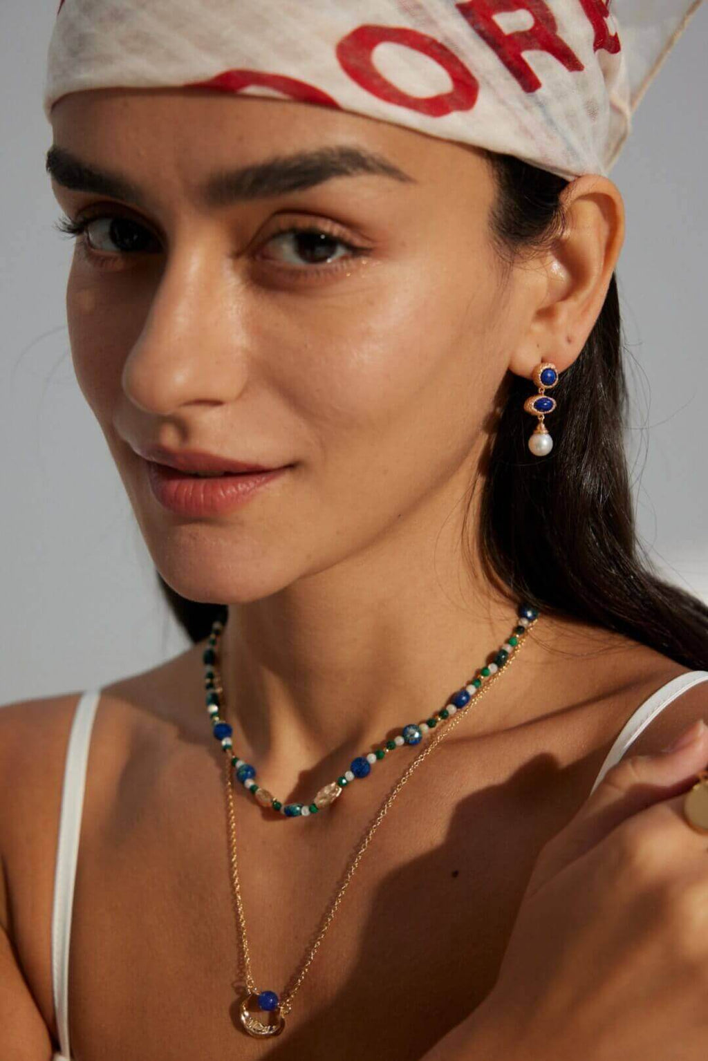 Natural pearl and lapis lazuli earrings adding daytime refinement to professional office attire.