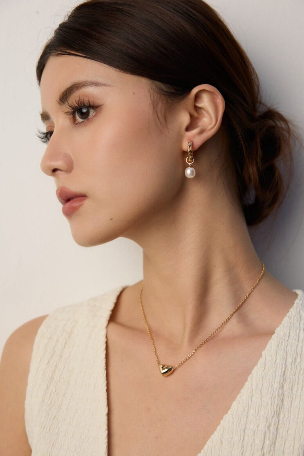 Elegant and graceful wood grain pearl earrings complementing a creative or professional workspace attire.