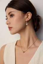 Elegant and graceful wood grain pearl earrings complementing a creative or professional workspace attire.