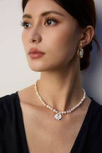 Enamel rose and pearl necklace resting elegantly on model's neck, showcasing its sophisticated style.