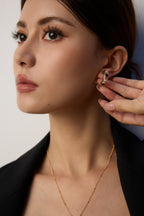 Classic pearl and onyx stud earrings adding touch of elegance to casual everyday outfits.