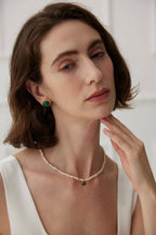 Front view of a model with hair pulled back, showcasing how the malachite studs add a pop of color to any look.