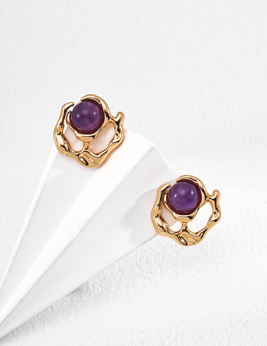 Close-up detail of the fluently designed liquid metal seamlessly encasing the noble purple amethyst gemstone.