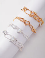 Two gold and silver bracelets on a white surface