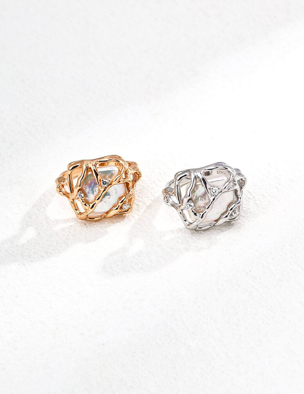 Two rings, one gold and one silver, on a white background