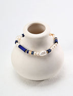 Flat lay of the bracelet showing the blue lapis lazuli and irregular baroque pearls.