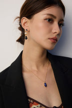 Woman showcasing Lapis Lazuli pendant with casual daytime attire.