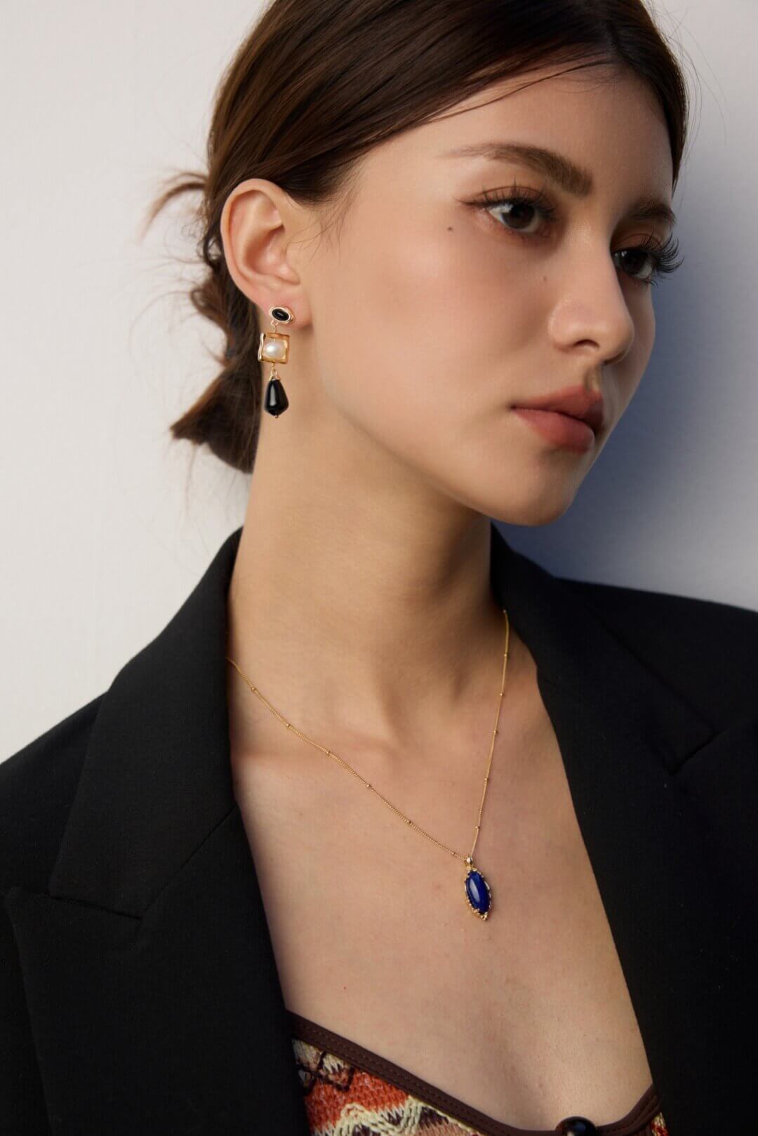 Woman showcasing Lapis Lazuli pendant with casual daytime attire.