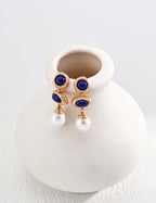 Deep blue lapis lazuli with golden pyrite specks combined with luminous natural pearls in elegant drop earrings.