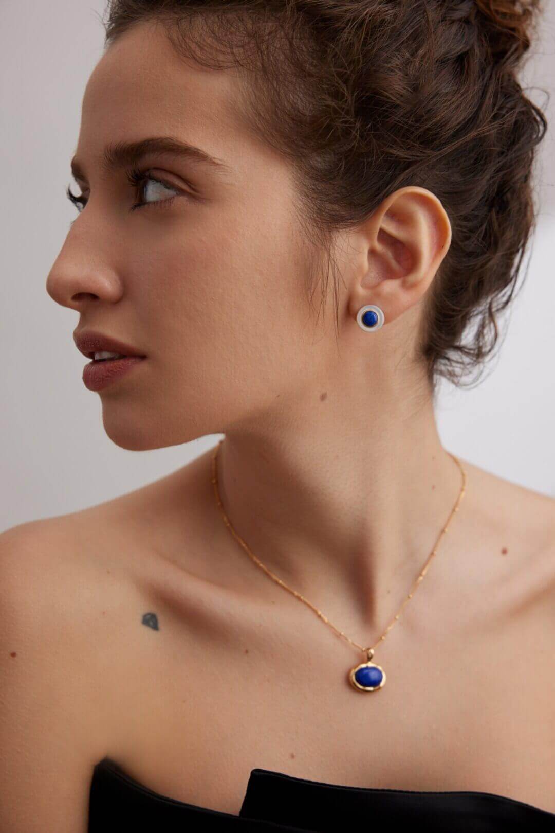 Side view of lapis lazuli shell stud earrings on model, showcasing 15mm elegant size and celestial-oceanic beauty.