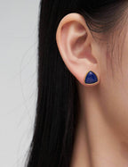Side view close-up of Lapis Lazuli stud earrings on model's ear, showcasing the celestial blue against skin tone.