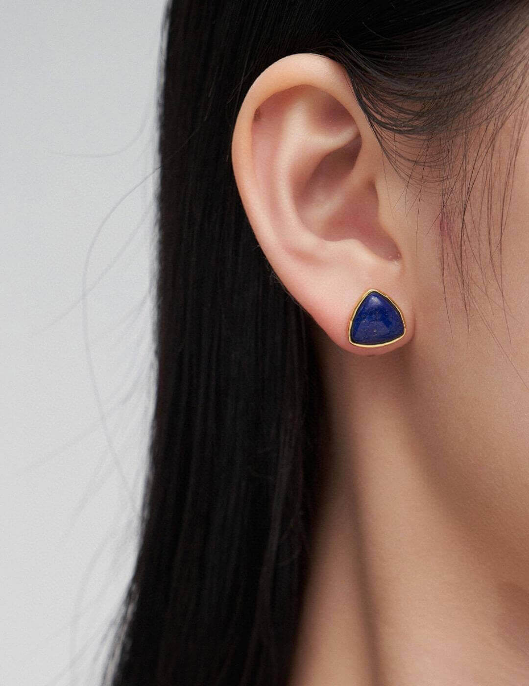 Side view close-up of Lapis Lazuli stud earrings on model's ear, showcasing the celestial blue against skin tone.
