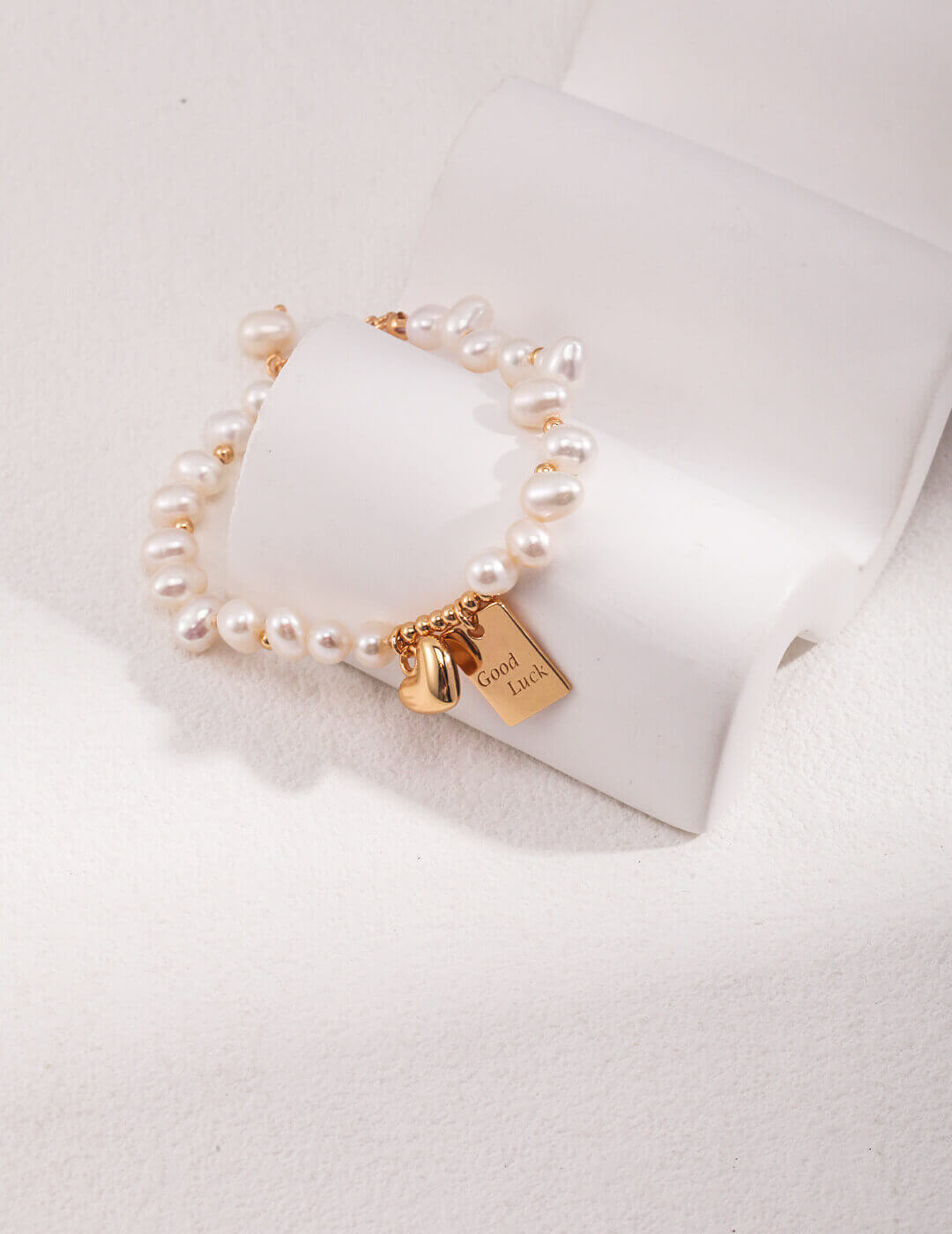 Vintage gold lucky pearl charm bracelet laid flat on a surface.