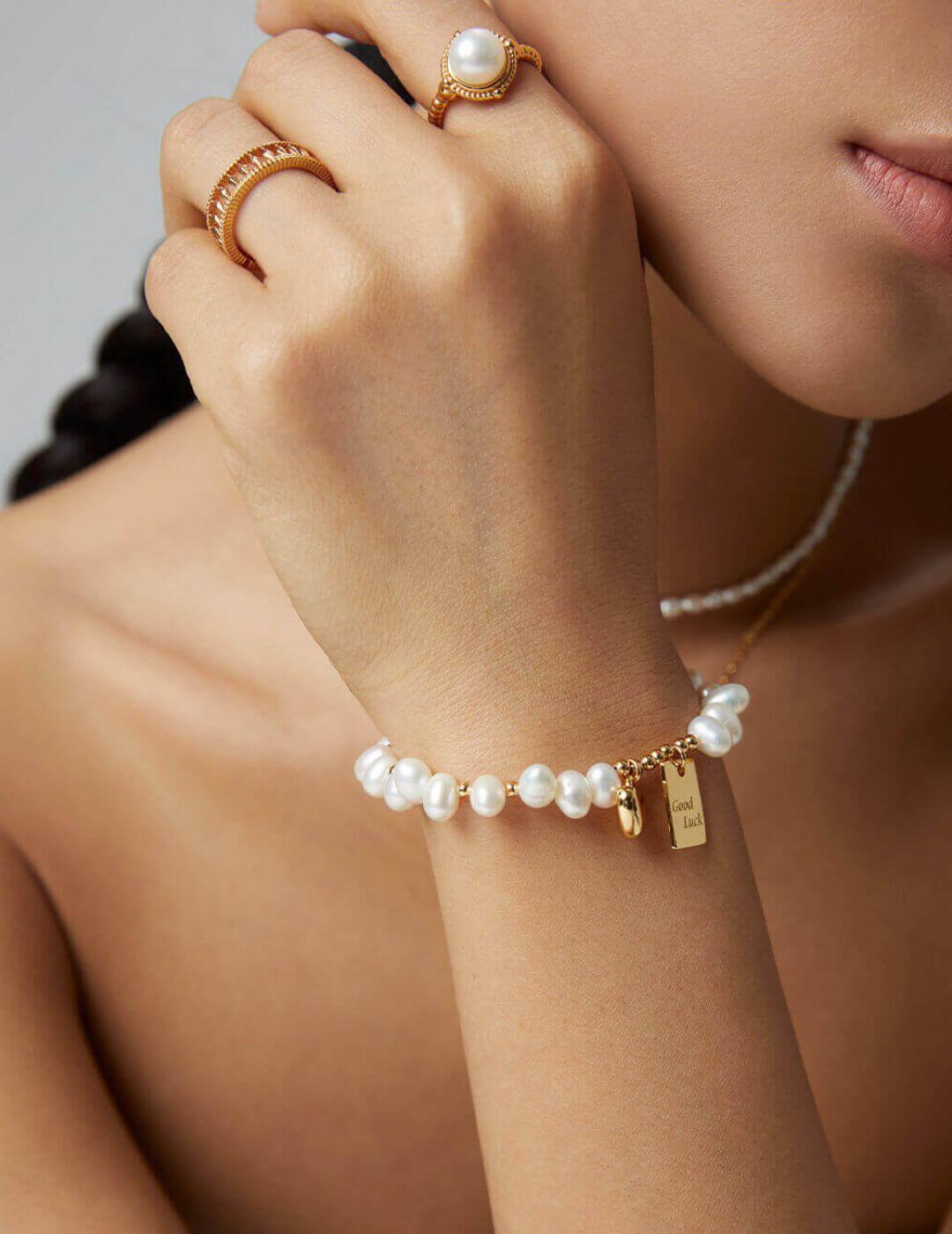 The bracelet styled with other dainty gold bracelets in a stack.