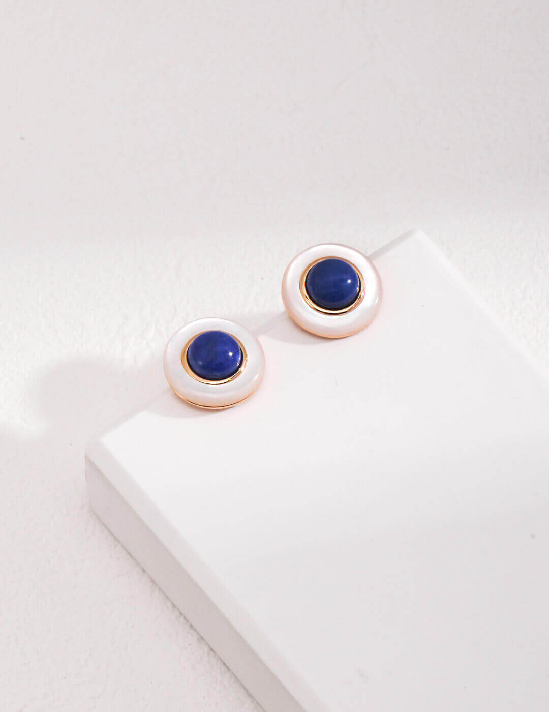 Luminous white shell reflecting subtle play of colors, capturing the beauty of the sea in earrings.