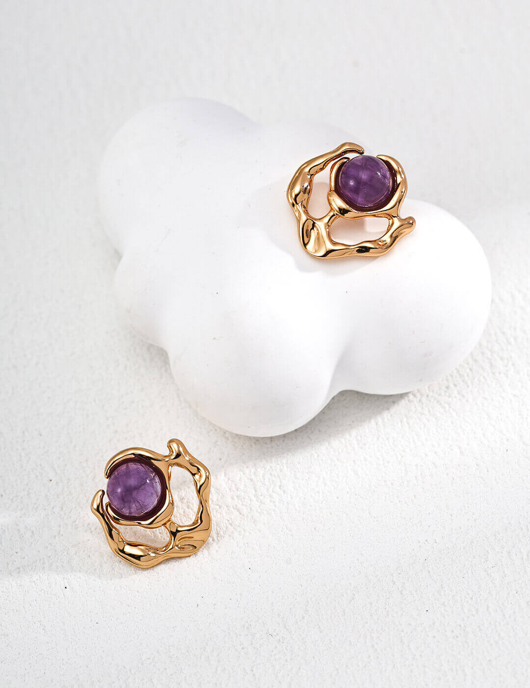 Minimalist designer amethyst earrings featuring natural fluently designed liquid metal that encases a captivating purple gemstone with pearl accents.