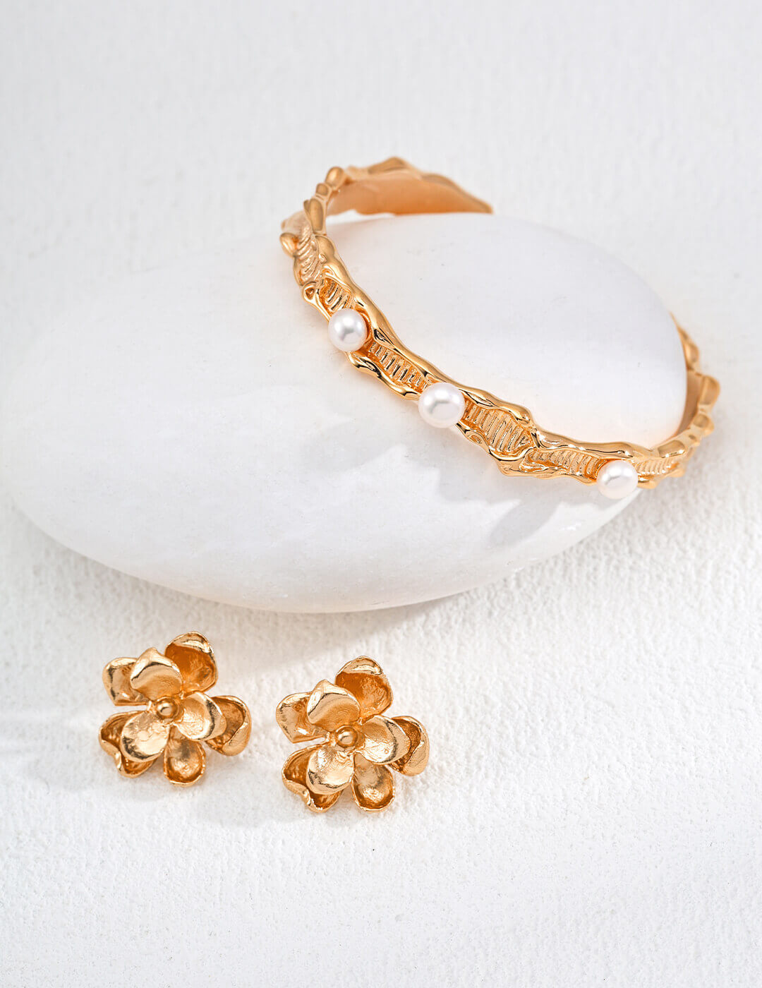Side profile view of the floral stud earrings worn on the ear.