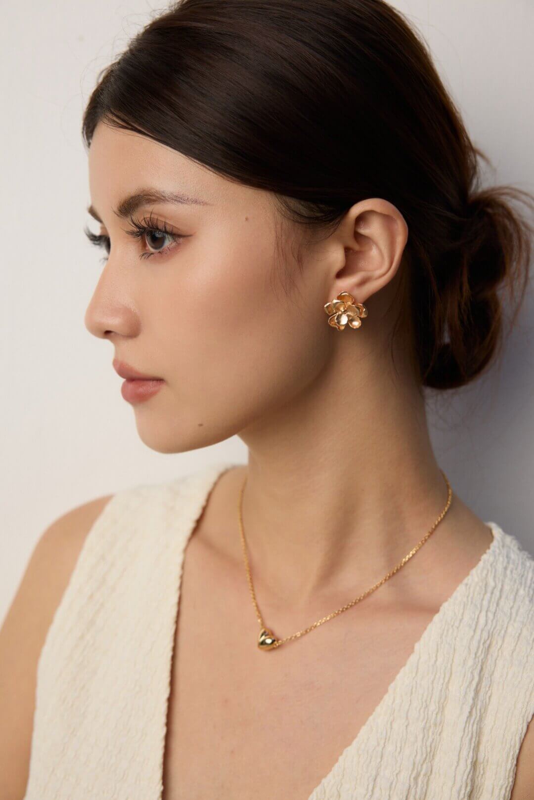 Minimalist floral earrings adding elegance to a casual daytime outfit.
