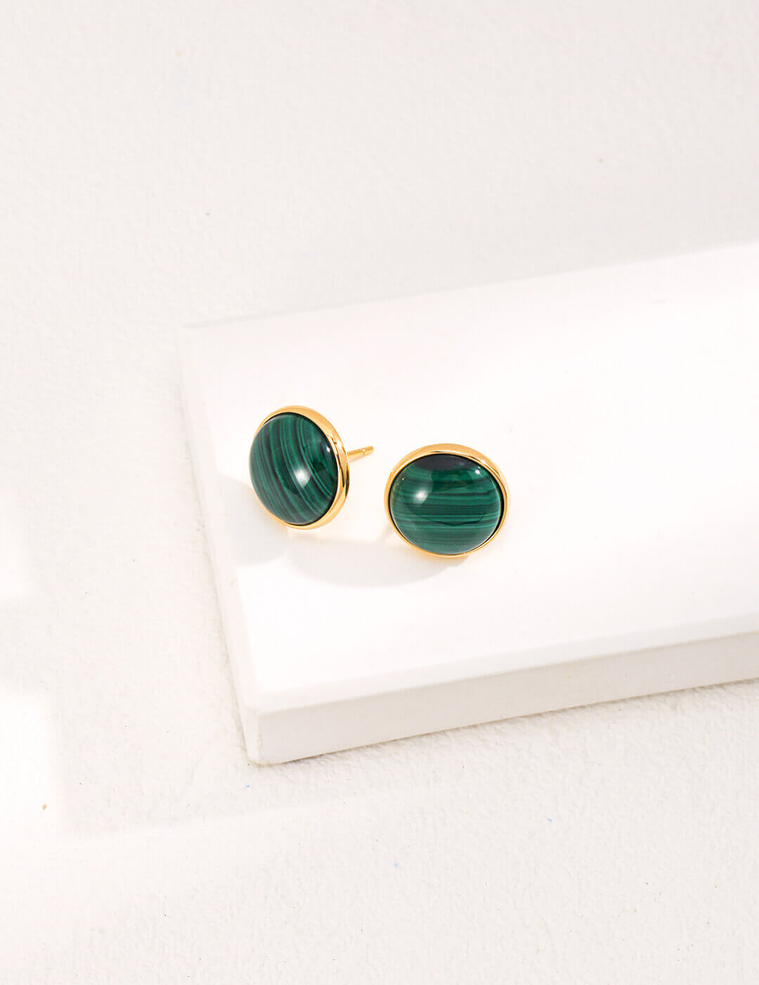 Extreme close-up of the natural green malachite stone in the minimalist stud earring, showing its unique patterns