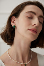 Flat lay composition featuring the minimalist malachite stud earrings alongside other minimalist jewelry