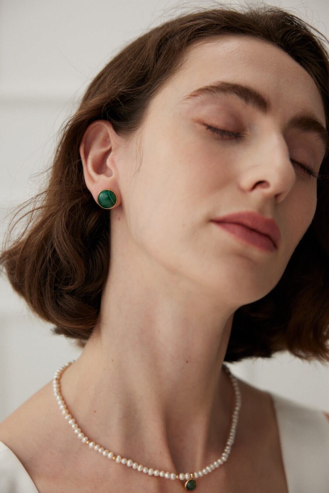 Flat lay composition featuring the minimalist malachite stud earrings alongside other minimalist jewelry