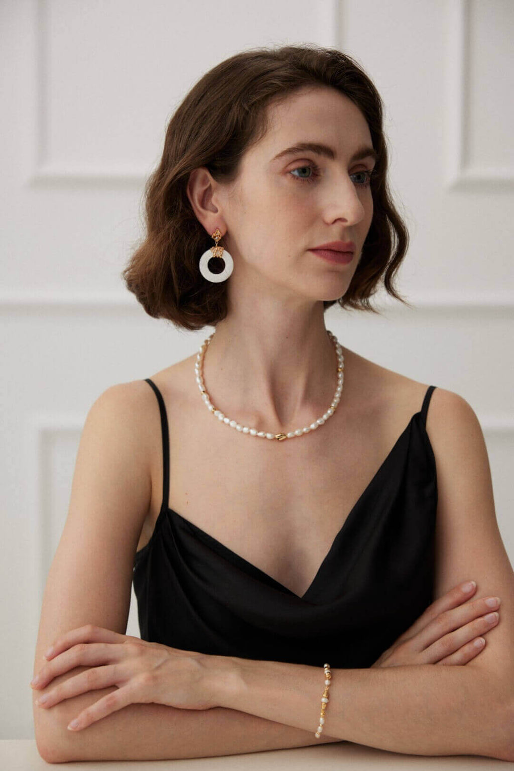 Front view of a model wearing the minimalist white shell studs, their vintage charm and openwork design adding elegance to any profile.