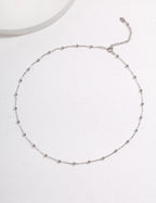 Silver beaded necklace on a white background