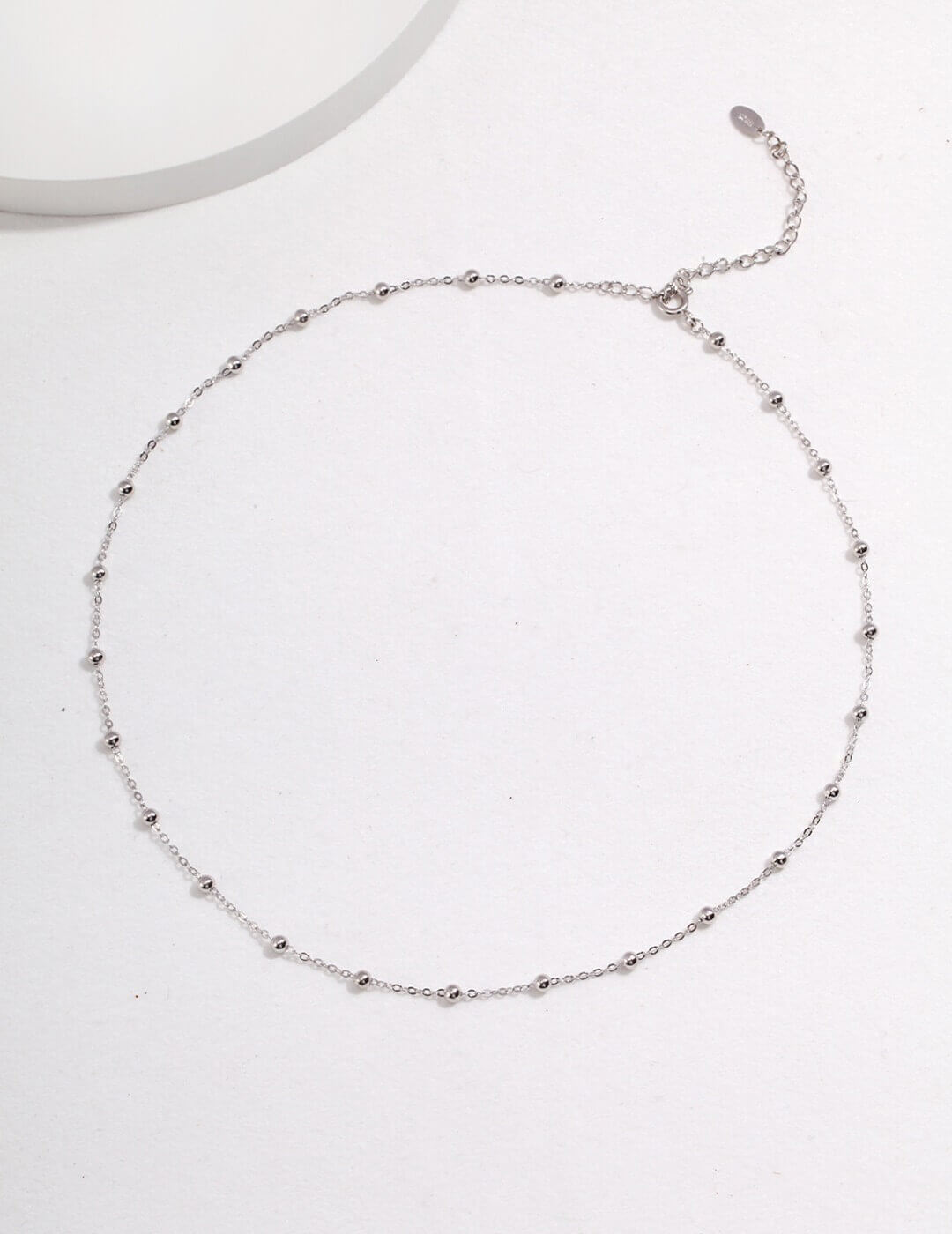 Silver beaded necklace on a white background