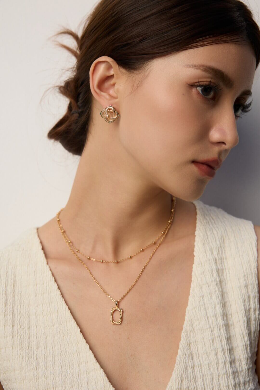 Woman wearing 18K gold plated beaded necklace layered style