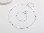 The complete minimalist S925 sterling silver bracelet and necklace set laid out together.