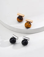 Close-up shot of the 1.2cm Tiger's Eye and Black Onyx stones, showing their natural patterns.