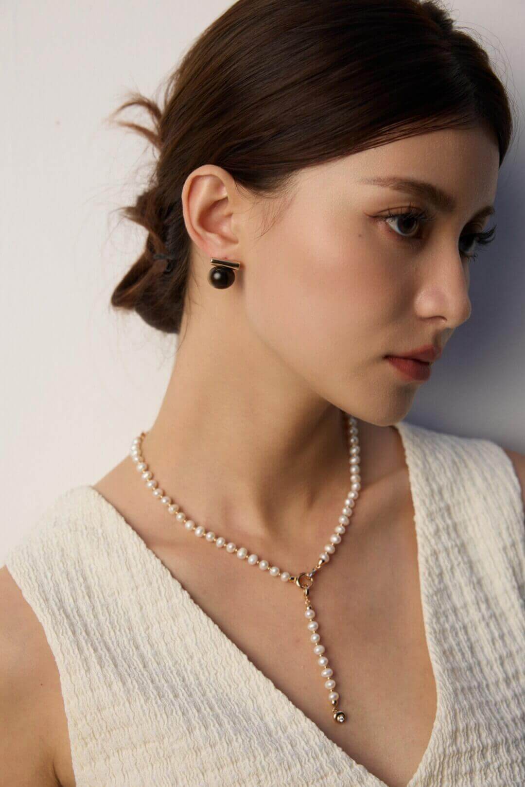 The studs worn with other minimalist gold and silver earrings.